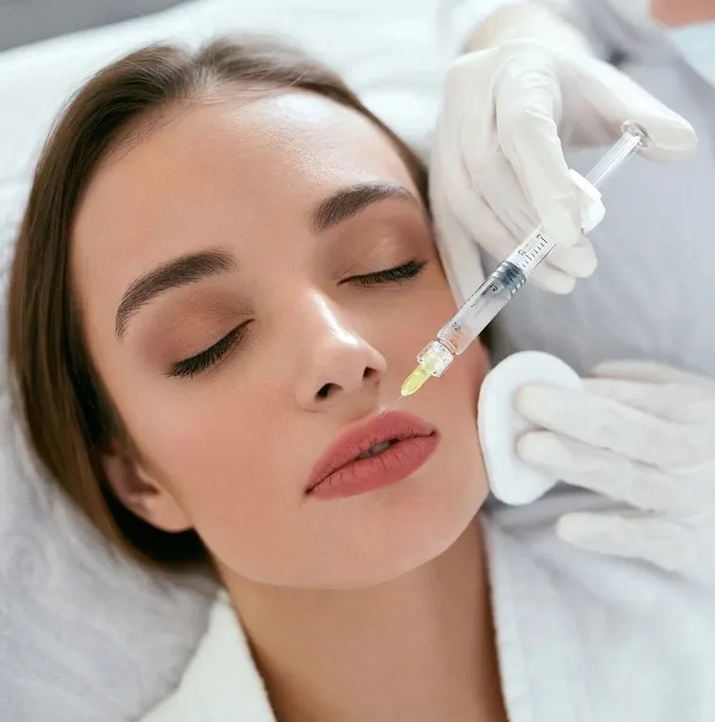 Clinician injecting lip filler into patient's upper lip during treatment